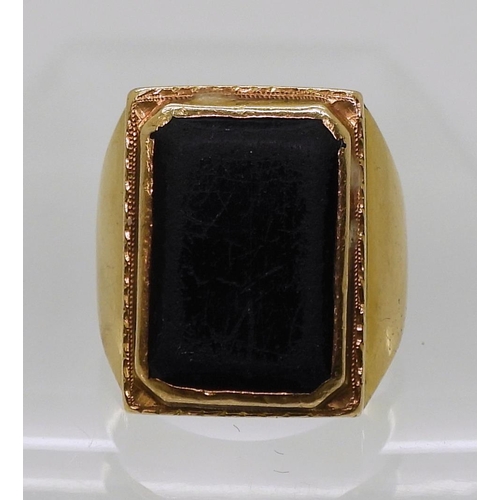 752 - A bright yellow metal ring, set with a black gem, stamped 90% with Chinese symbols, size R, weight 1... 