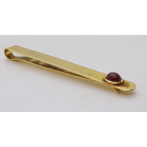 766 - A yellow metal tie slide set with a cabochon ruby weight 11.2gms