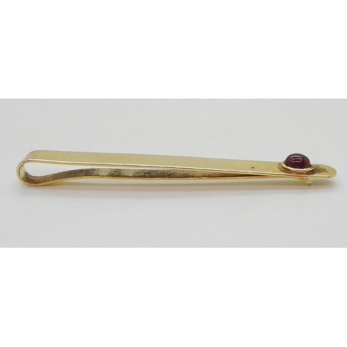 766 - A yellow metal tie slide set with a cabochon ruby weight 11.2gms