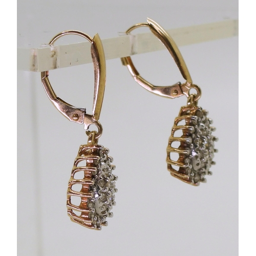 772 - A pair of 10k gold diamond drop earrings with continental hoop closure, set with estimated approx 0.... 