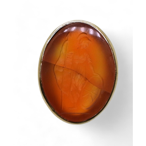 792 - A bright yellow metal signet ring set with a large carnelian intaglio carved with Brittania (cracked... 