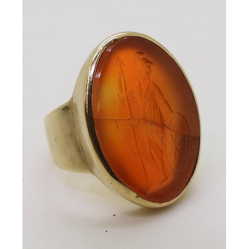 792 - A bright yellow metal signet ring set with a large carnelian intaglio carved with Brittania (cracked... 