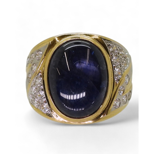 804 - A yellow metal ring set with a star sapphire and clear gems, size S, weight 13.7gms