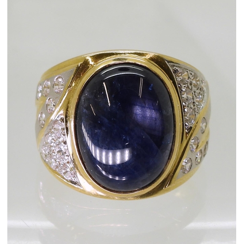 804 - A yellow metal ring set with a star sapphire and clear gems, size S, weight 13.7gms