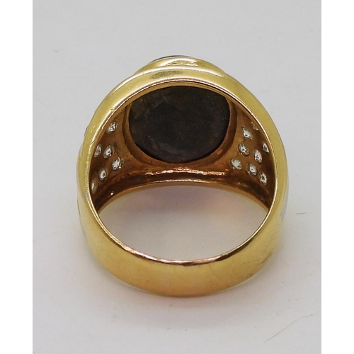 804 - A yellow metal ring set with a star sapphire and clear gems, size S, weight 13.7gms