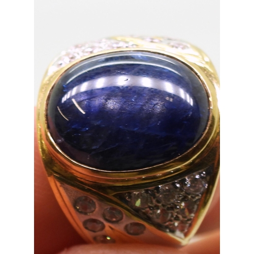 804 - A yellow metal ring set with a star sapphire and clear gems, size S, weight 13.7gms