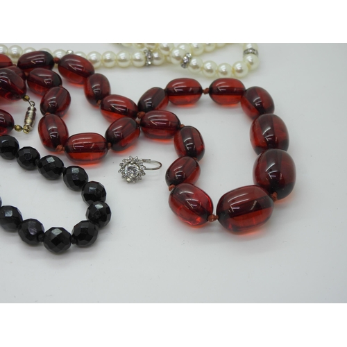 892 - *WITHDRAWN* A string of cherry amber coloured beads, weight 64gms, a string of black pearls with a 9... 