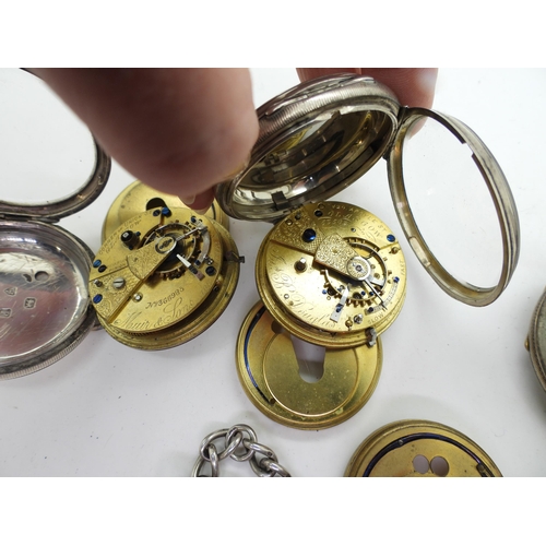 896 - Four silver open face pocket watches, and a silver fob chain with attached key and cannon charm. The... 