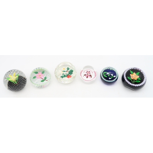 214 - A collection of Caithness flower paperweights including Winter Flower, Rose, with 100 in number cane... 