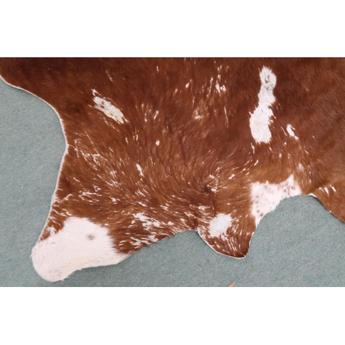 39 - A contemporary brown and cream tanned cowhide rug, approximately 247cm long x 217cm wide