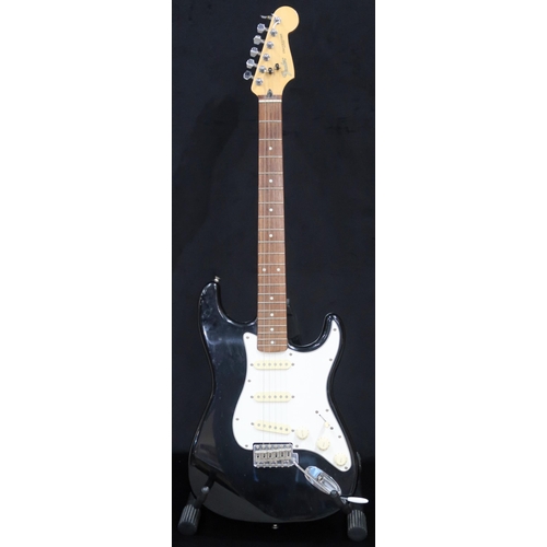 391 - A Fender Stratocaster in black and white scratch plate with a gig bag.This Instrument is from the es... 