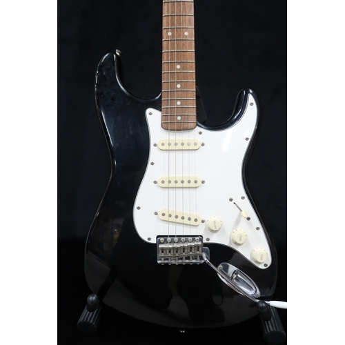 391 - A Fender Stratocaster in black and white scratch plate with a gig bag.This Instrument is from the es... 