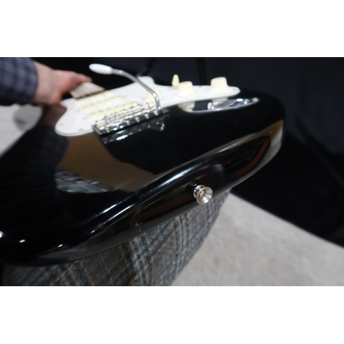 391 - A Fender Stratocaster in black and white scratch plate with a gig bag.This Instrument is from the es... 