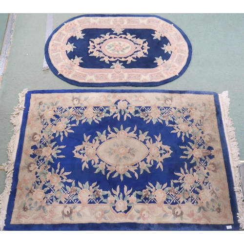 73 - A lot of two assorted blue ground Oriental style rugs with floral central medallions and borders, re... 