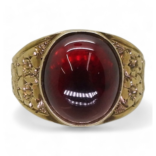 2708 - A GARNET RINGthe mount in 9ct gold with engraved flower details to the shoulders is hallmarked Birmi... 