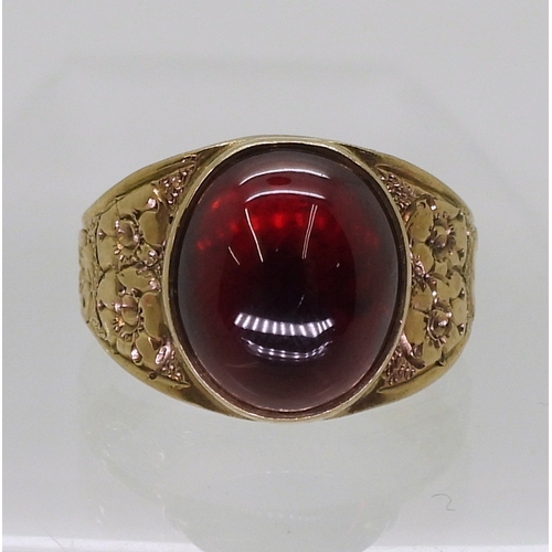 2708 - A GARNET RINGthe mount in 9ct gold with engraved flower details to the shoulders is hallmarked Birmi... 