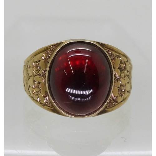 2708 - A GARNET RINGthe mount in 9ct gold with engraved flower details to the shoulders is hallmarked Birmi... 