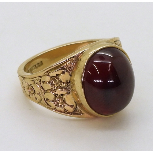 2708 - A GARNET RINGthe mount in 9ct gold with engraved flower details to the shoulders is hallmarked Birmi... 