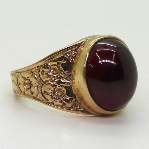 2708 - A GARNET RINGthe mount in 9ct gold with engraved flower details to the shoulders is hallmarked Birmi... 