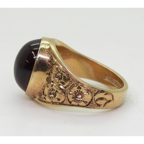 2708 - A GARNET RINGthe mount in 9ct gold with engraved flower details to the shoulders is hallmarked Birmi... 