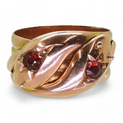 2711 - A ROSE GOLD DOUBLE SNAKE RINGthe 9ct gold serpents heads are set with garnets, bears a London hallma... 