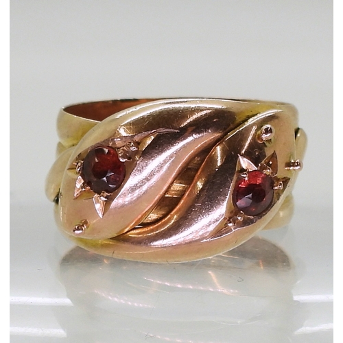 2711 - A ROSE GOLD DOUBLE SNAKE RINGthe 9ct gold serpents heads are set with garnets, bears a London hallma... 