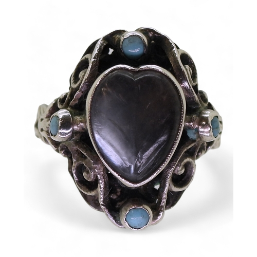 2718 - AN ARTS & CRAFTS RINGmade in sterling silver, set with a leaf carved heart shape moonstone, and ... 