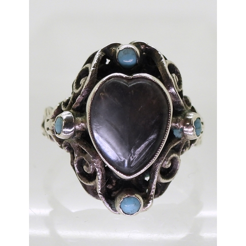 2718 - AN ARTS & CRAFTS RINGmade in sterling silver, set with a leaf carved heart shape moonstone, and ... 