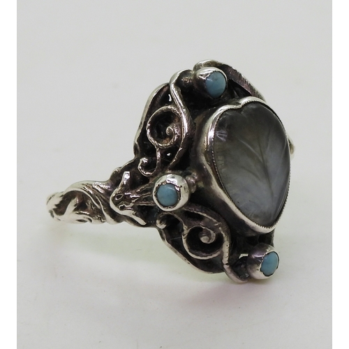 2718 - AN ARTS & CRAFTS RINGmade in sterling silver, set with a leaf carved heart shape moonstone, and ... 