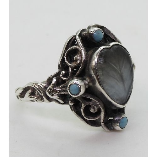 2718 - AN ARTS & CRAFTS RINGmade in sterling silver, set with a leaf carved heart shape moonstone, and ... 