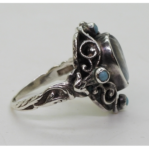 2718 - AN ARTS & CRAFTS RINGmade in sterling silver, set with a leaf carved heart shape moonstone, and ... 