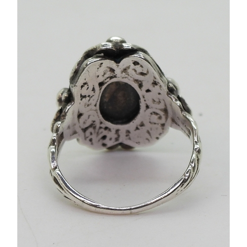 2718 - AN ARTS & CRAFTS RINGmade in sterling silver, set with a leaf carved heart shape moonstone, and ... 