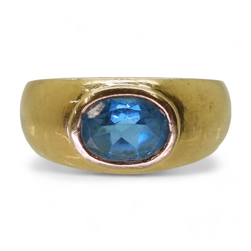 2730 - A GENTS BLUE TOPAZ RINGin a bright yellow metal domed ring mount, stamped 750. Finger size W1/2, wei... 