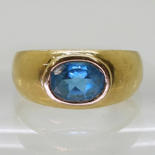 2730 - A GENTS BLUE TOPAZ RINGin a bright yellow metal domed ring mount, stamped 750. Finger size W1/2, wei... 