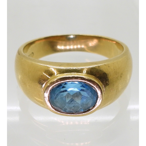 2730 - A GENTS BLUE TOPAZ RINGin a bright yellow metal domed ring mount, stamped 750. Finger size W1/2, wei... 