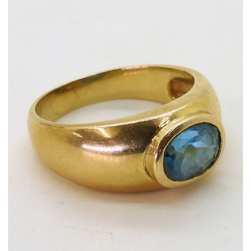 2730 - A GENTS BLUE TOPAZ RINGin a bright yellow metal domed ring mount, stamped 750. Finger size W1/2, wei... 