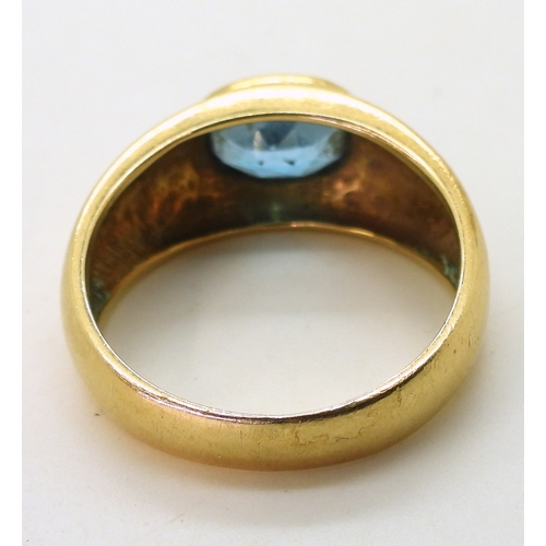 2730 - A GENTS BLUE TOPAZ RINGin a bright yellow metal domed ring mount, stamped 750. Finger size W1/2, wei... 