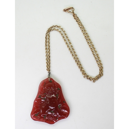 2740 - AN ART DECO PRESSED GLASS PENDANTin dark pink glass, depicting a troll character, with big ears amon... 