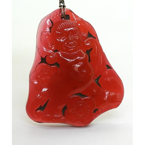 2740 - AN ART DECO PRESSED GLASS PENDANTin dark pink glass, depicting a troll character, with big ears amon... 