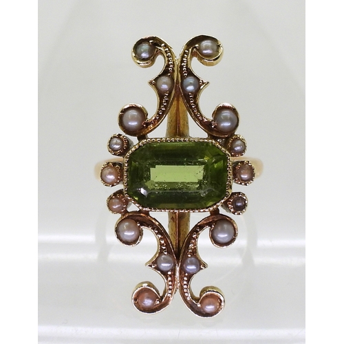 2748 - A VINTAGE PERIDOT & PEARL RINGwith an unusual linear scrolled design, the bright yellow metal he... 