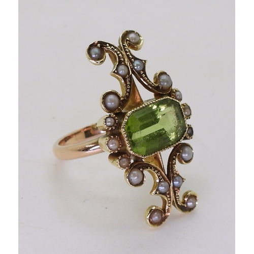 2748 - A VINTAGE PERIDOT & PEARL RINGwith an unusual linear scrolled design, the bright yellow metal he... 