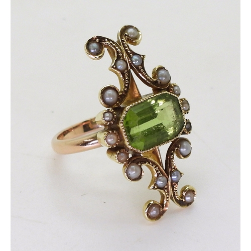 2748 - A VINTAGE PERIDOT & PEARL RINGwith an unusual linear scrolled design, the bright yellow metal he... 