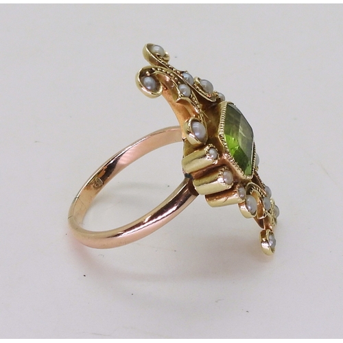 2748 - A VINTAGE PERIDOT & PEARL RINGwith an unusual linear scrolled design, the bright yellow metal he... 