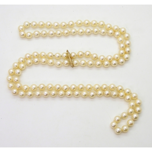 2752 - AN OPERA LENGTH OF PEARLSwith a 14k gold pearl clip, each pearl is approx 7mm, with a total length o... 