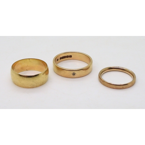 9021 - Three 9ct gold wedding rings, sizes W (with a tiny star set diamond), size Q1/2, size N, weight toge... 