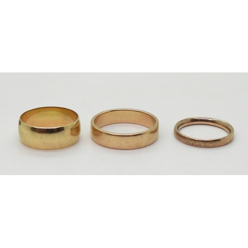 9021 - Three 9ct gold wedding rings, sizes W (with a tiny star set diamond), size Q1/2, size N, weight toge... 