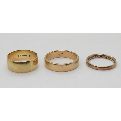 9021 - Three 9ct gold wedding rings, sizes W (with a tiny star set diamond), size Q1/2, size N, weight toge... 