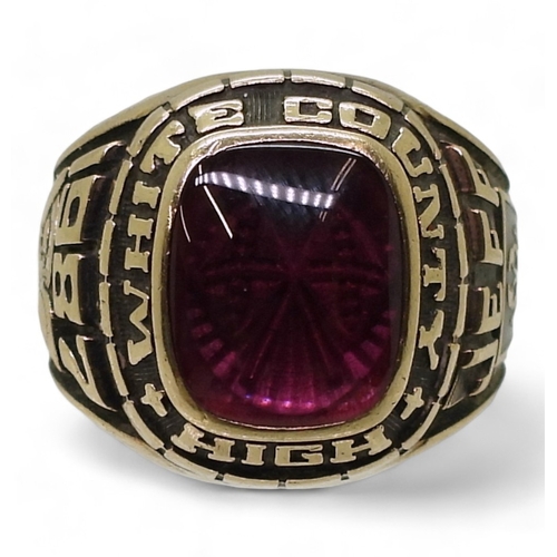 9127 - A 10k Josten's brand American college  ring, for White County High 1987, set with a pink glass gem, ... 