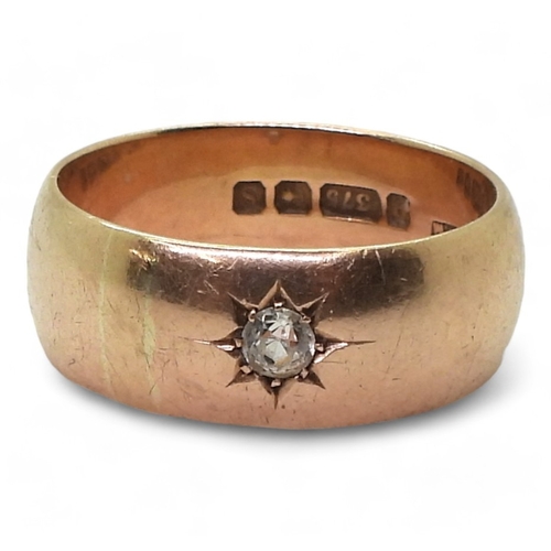 9134 - a 9ct gold wide wedding ring star set with a clear gem, size X, weight 8.7gms