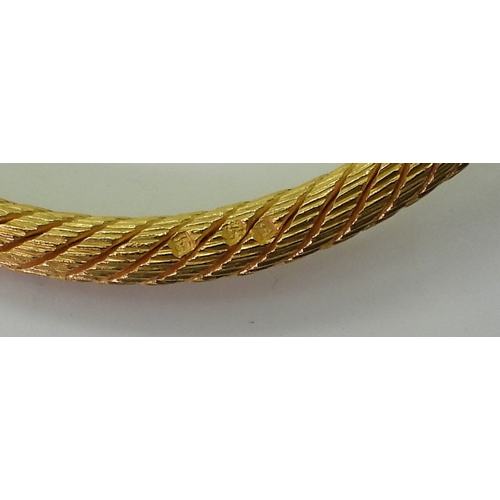 2772 - AN ARABIC GOLD SNAKE BANGLEthe twisted wire body has a springy feel to it, with solid tail and head,... 